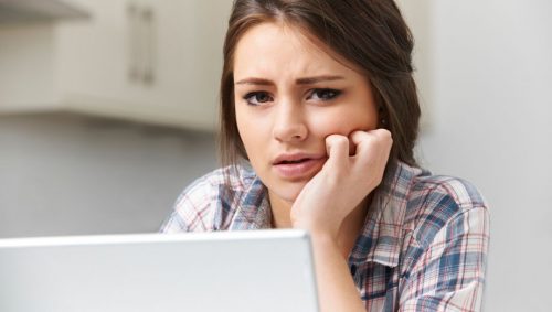 Een mevrouw kijkt bedenkelijk naar haar beeldscherm