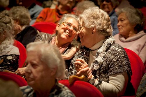 Twee ouderen die in het publiek naar een show kijken