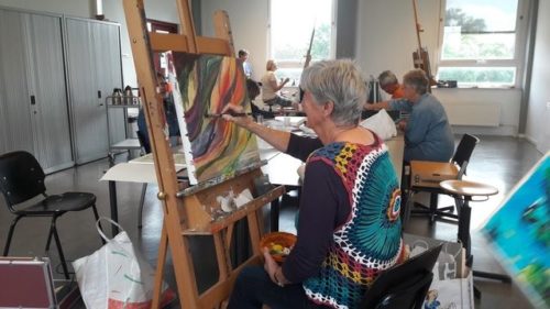 Een oudere vrouw die aan het schilderen is