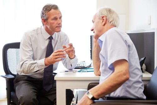 Een huisarts in gesprek met een patient.