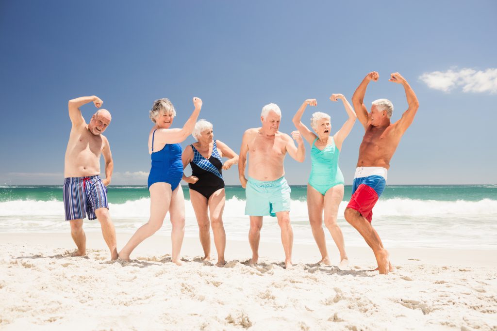 Ouderen mensen op het strand die hun spieren aan het laten zien zijn