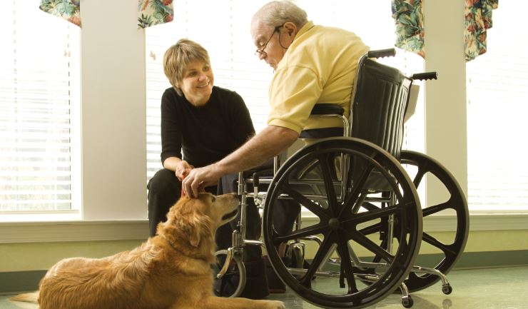 Oudere in een rolstoel met een hond